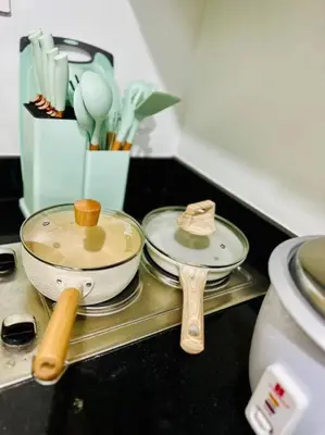 a counter top with two pans and wooden spoons at Cozy 1BR at Shore 2 with balcony in Manila