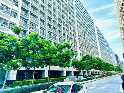 a car parked in front of a large building at Cozy 1BR at Shore 2 with balcony in Manila