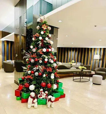 a christmas tree with ornaments in a lobby at Cozy 1BR at Shore 2 with balcony in Manila