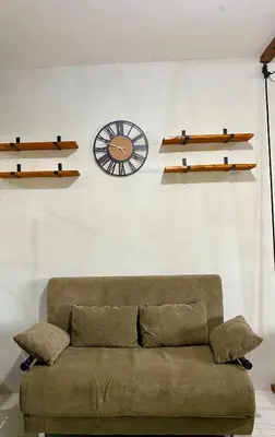 a living room with a couch and a clock on the wall at Casa Cabilao Staycation in Santa Rosa