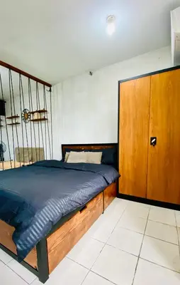 a bedroom with a bed and a wooden cabinet at Casa Cabilao Staycation in Santa Rosa