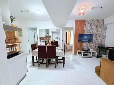 a kitchen and living room with a table and a television at Azure resort Paranaque deluxe 8 plus 2toddler free in Manila