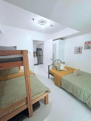 a bedroom with two bunk beds and a kitchen at Azure resort Paranaque deluxe 8 plus 2toddler free in Manila