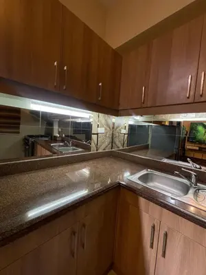 a kitchen with wooden cabinets and a sink at Two Bedroom Fully Furnished 70sqm CONDO MIREA RESIDENCES PASIG in Manila