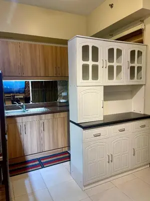 a kitchen with white cabinets and a white refrigerator at 2BHK with Balcony Fully Furnished-70sqm Condo Pasig in Manila