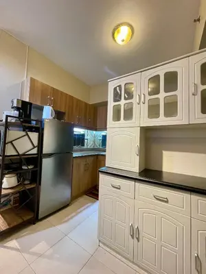 a kitchen with white cabinets and a stainless steel refrigerator at 2BHK with Balcony Fully Furnished-70sqm Condo Pasig in Manila