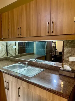 a kitchen with a sink and wooden cabinets at 2BHK with Balcony Fully Furnished-70sqm Condo Pasig in Manila