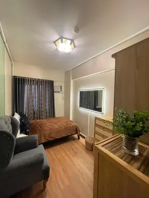 a bedroom with a bed and a couch in a room at 2BHK with Balcony Fully Furnished-70sqm Condo Pasig in Manila