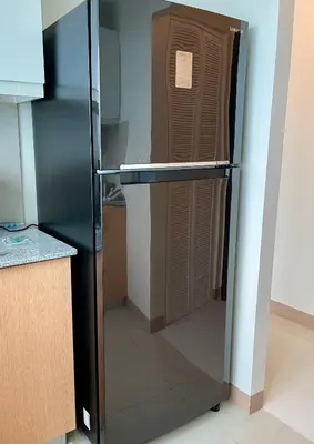 a black refrigerator in a kitchen with its door open at Residential Resort Condo by the Bay in Manila