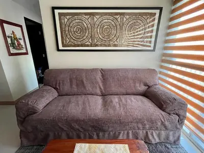 a brown couch in a living room with a table at Residential Resort Condo by the Bay in Manila