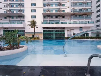 a swimming pool with a shower in front of a building at The Beacon Makati by Cozi Condotels in Manila