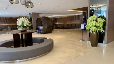 a lobby of a hotel with a table and flowers at ART's Nest at Shore Residences in Manila