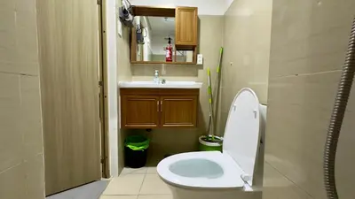 a bathroom with a toilet and a sink at ART's Nest at Shore Residences in Manila
