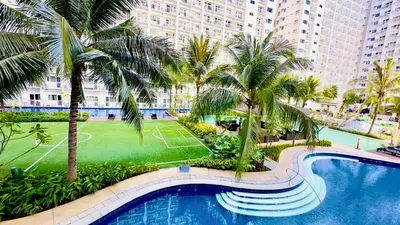 an overhead view of a swimming pool with palm trees at ART's Nest at Shore Residences in Manila