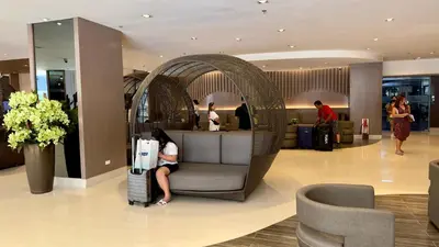 a woman sitting on a chair in a lobby at ART's Nest at Shore Residences in Manila
