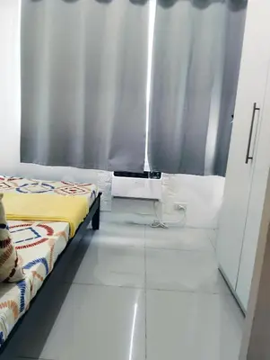 a room with a bed and a window with curtains at Glenda Place Aurum At Sea Residences near Moa in Manila