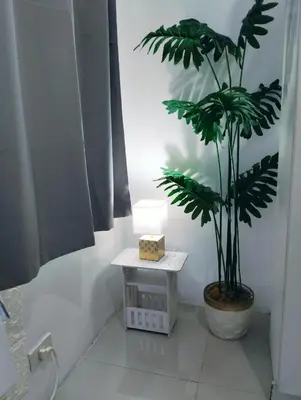 a plant in a pot next to a table in a bathroom at Glenda Place Aurum At Sea Residences near Moa in Manila