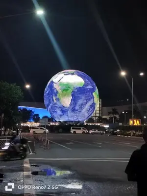a large globe on the side of a street at night at Glenda Place Aurum At Sea Residences near Moa in Manila