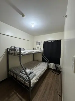 a small room with two bunk beds in it at Acacia Estates Taguig in Manila