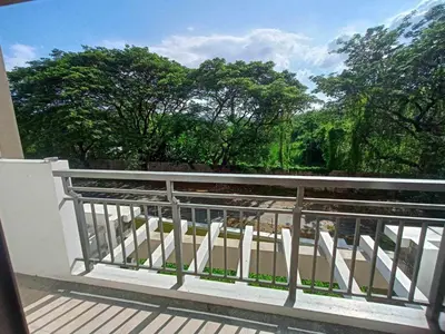 a balcony with a view of the trees at Acacia Estates Taguig in Manila