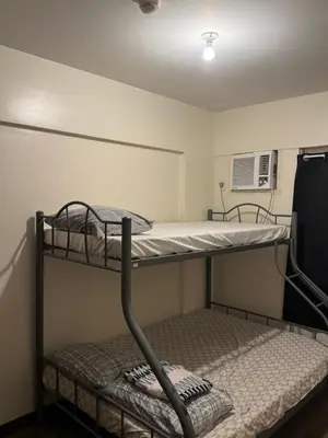 two bunk beds in a room with a fan at Acacia Estates Taguig in Manila