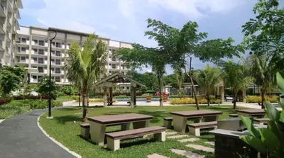 a park with benches in front of a building at Acacia Estates Taguig in Manila