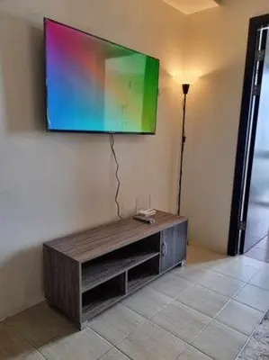 a flat screen tv hanging on a wall at Casa REYNA at KASARA Urban Residences in Manila