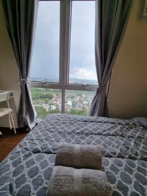 a bedroom with a bed with a large window at Casa REYNA at KASARA Urban Residences in Manila