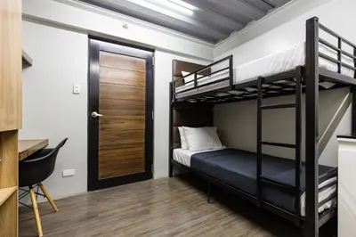 a bedroom with two bunk beds and a door at District Inn in Manila