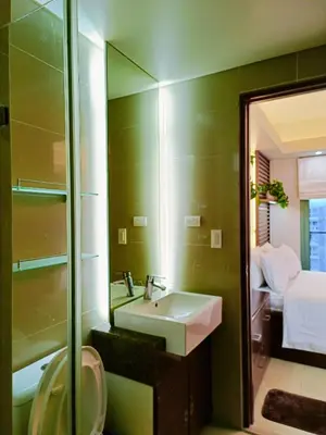 a bathroom with a sink and a mirror at Two Palmtree Villas Across Manila Airport Terminal 3 -JJRMK Condotel in Manila