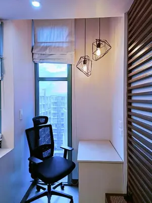 a black chair sitting in a room with a window at Two Palmtree Villas Across Manila Airport Terminal 3 -JJRMK Condotel in Manila