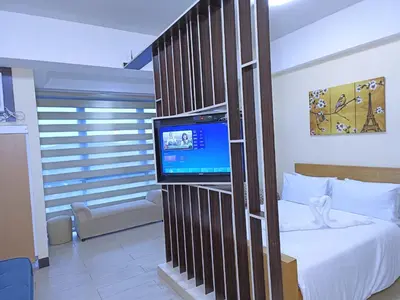 a bedroom with a bed and a tv in a room at Near Terminal 3 Two Palmtree Villas- Walking distance only (JJRMK) in Manila