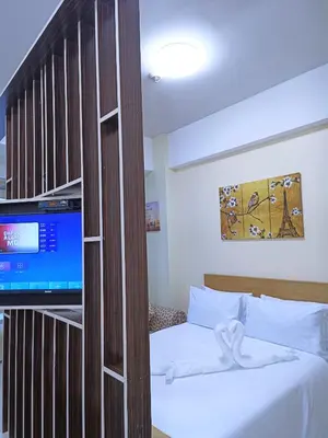 a bedroom with a bed and a tv in a room at Near Terminal 3 Two Palmtree Villas- Walking distance only (JJRMK) in Manila