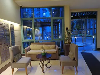 a living room with a couch and two chairs and a table at Near Terminal 3 Two Palmtree Villas- Walking distance only (JJRMK) in Manila