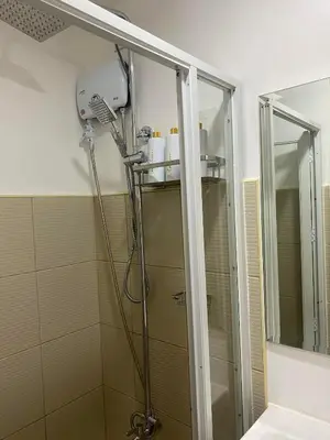 a shower in a bathroom with a glass door at Suzi's Place @ Green 2 Residences Free Wi-fi & Netflix in Dasmariñas