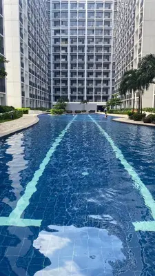 a large swimming pool in front of a tall building at Condo Suite/Apartment Pasay SM MOA - Stay Cozy & Boujee in Manila