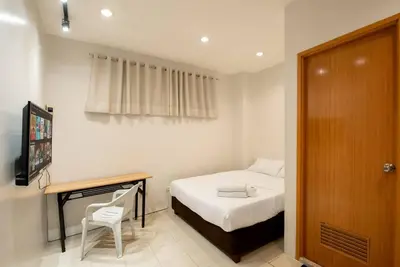 a bedroom with a bed and a desk with a chair at JP Santiago Studio Makati J204 in Manila