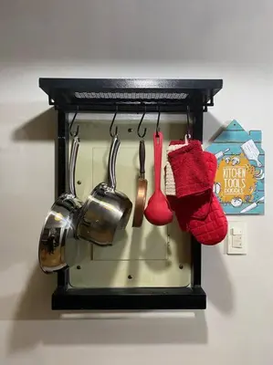 a rack with pots and utensils on a wall at Relax@Samaya Pasig in Manila