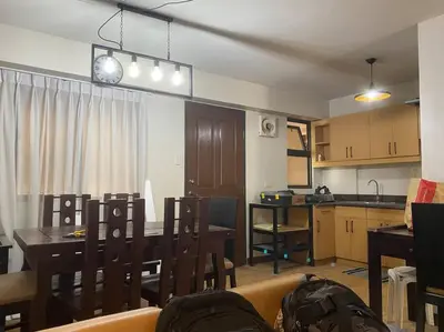 a living room with a dining room table and a kitchen at Relax@Samaya Pasig in Manila