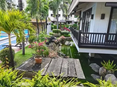 a garden with a wooden deck next to a house at Relax@Samaya Pasig in Manila