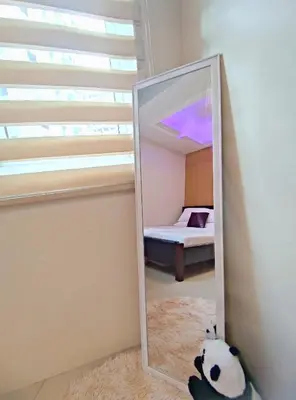 a mirror in front of a bedroom with a bed at Shell res nr MOA 2BR free parking in Manila