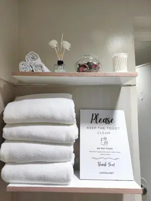 a stack of towels on a shelf in a bathroom at Shell res nr MOA 2BR free parking in Manila