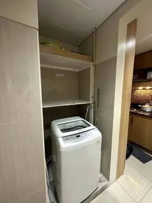 a small kitchen with a washing machine in a room at Shell res nr MOA 2BR free parking in Manila