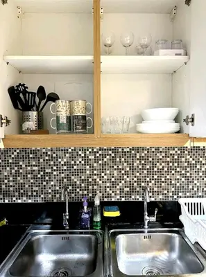 a kitchen with two sinks and a tiled wall at Shell res nr MOA 2BR free parking in Manila