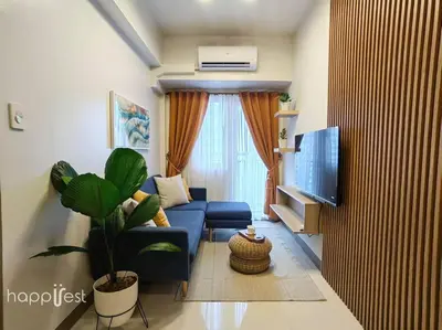 a living room with a blue couch and a tv at Happirest at Coast Residences, Pasay - 1 Bedroom with Balcony in Manila