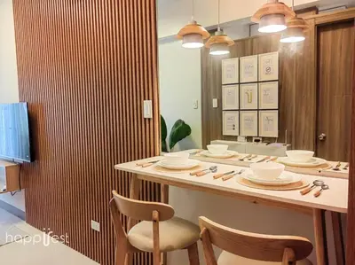 a kitchen with a counter with chairs and plates on it at Happirest at Coast Residences, Pasay - 1 Bedroom with Balcony in Manila