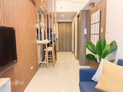 a living room with a blue couch and a tv at Happirest at Coast Residences, Pasay - 1 Bedroom with Balcony in Manila