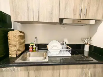 a kitchen counter with a sink and a dish rack at Happirest at Coast Residences, Pasay - 1 Bedroom with Balcony in Manila