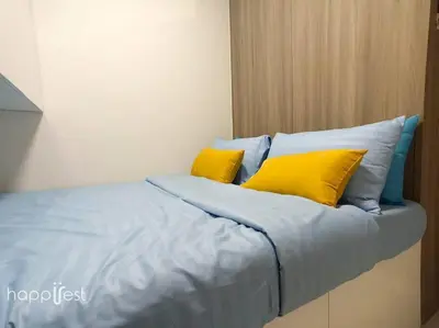 a bed with yellow and blue pillows on it at Happirest at Coast Residences, Pasay - 1 Bedroom with Balcony in Manila