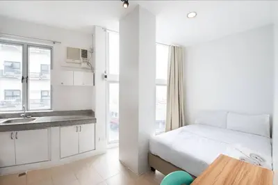 a white bedroom with a bed and a sink at JP Santiago Studio Makati J206 in Manila
